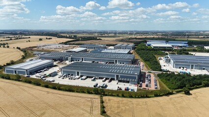 Aerial drone shot of distribution warehouses and data center logistics hub with truck cargo...