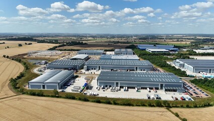 Aerial drone shot of distribution warehouses and data center logistics hub with truck cargo...
