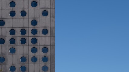 Modern Building Facade with Round Windows and Blue Sky