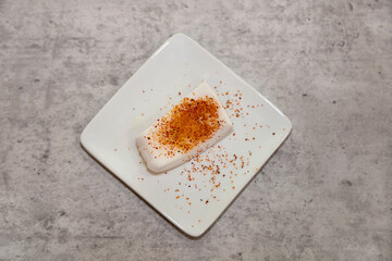 A piece of coconut meat with lime and chilli powder.