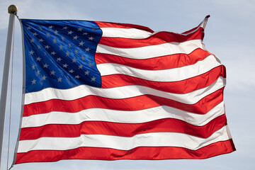 Close up of flag waving on the blue sky.