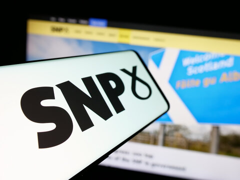 Stuttgart, Germany - 07-09-2025: Smartphone with logo of Scottish National Party (SNP) on screen in front of website. Focus on center-left of phone display.