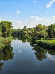 Lake in the park.
Serene River Landscape Under a Clear Blue Sky with Lush Green Trees