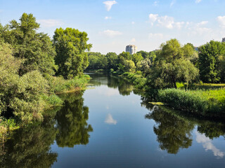 river in the park.
River flowing through lush green trees on a sunny day