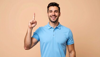 Smiling Man Points Upwards in Light Blue Polo Shirt Against a Tan Background