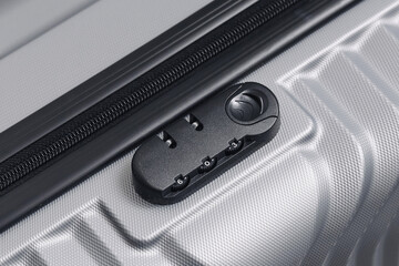 Close up of suitcase lock. Secure code mechanism on grey travel luggage. Safety system with zipper...