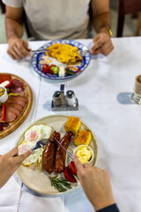 Traditional Serbian Breakfast with Hands Reaching for Food