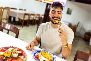 Young Man Enjoying Scrambled Eggs and Vegetables for Breakfast
