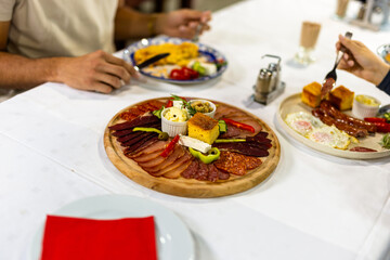 Traditional Serbian Breakfast with Hands Reaching for Food