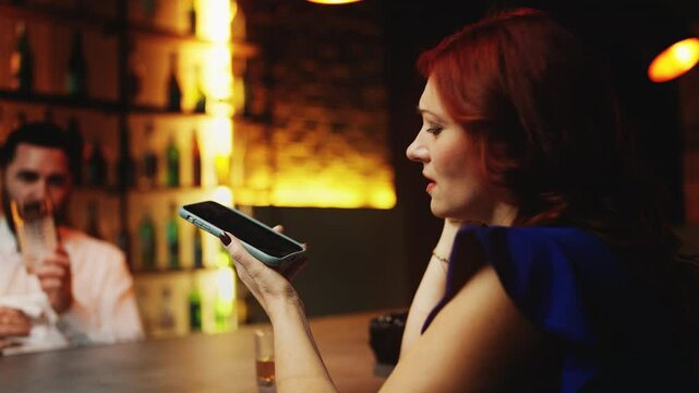 Emotional drunk woman calling her ex at bar, bartender listening silently