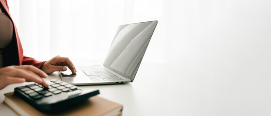 Accountant working at desk using calculator to calculate company's annual financial and tax report. financial concept