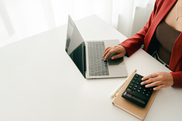 Accountant working at desk using calculator to calculate company's annual financial and tax report. financial concept