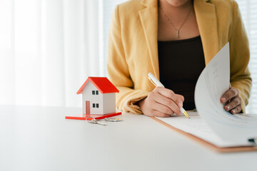 Portrait of a Home Purchase Agreement
Real estate agent delivers a model home to a client,...