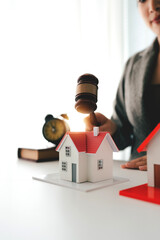 Real estate auction concept with hammer and model house which is the symbol of real estate market. Real estate office open house auction for interested people to join the auction house.