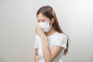 Unhealthy sickness, unwell asian young woman wearing mask coughing, have sore throat, suffering symptom cough feeling bad and healthcare of air pollution and dust, PM2.5 isolated white background.