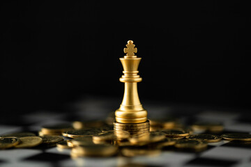 Gold chess king on a stack of coins. Business strategy concept for financial success, investment...