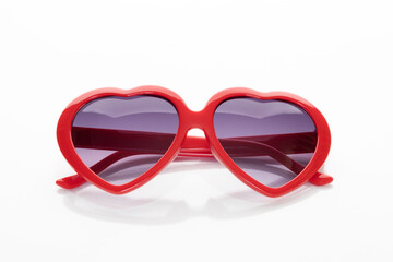 Red heart shaped sunglasses for fashion and love concepts. A fun, retro style accessory for a party, summer, or Valentine's Day. isolated on white background with clipping path.