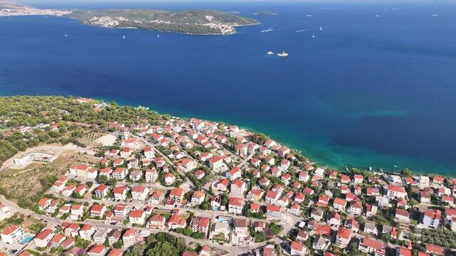 Drone shows the marine channel stretching between Seget Vranjica and Ciovo with boats, waves, and clear water moving gently through the scenic coastal zone