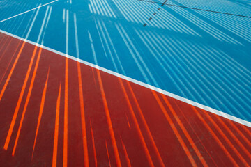 Abstract sunlight casting patterns on court surface