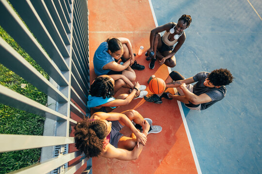 Group of friends resting after basketball game outdoors
