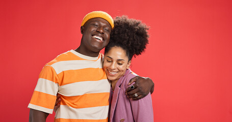 Hug, smile and black couple in studio, love and bonding together on red background. Romance, embrace and man with woman, relationship and support with happiness, trust and commitment with marriage