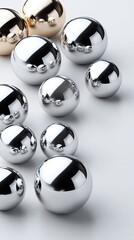 Various sizes of silver spheres cluster in the lower left corner against a white background, presenting a sleek and modern design