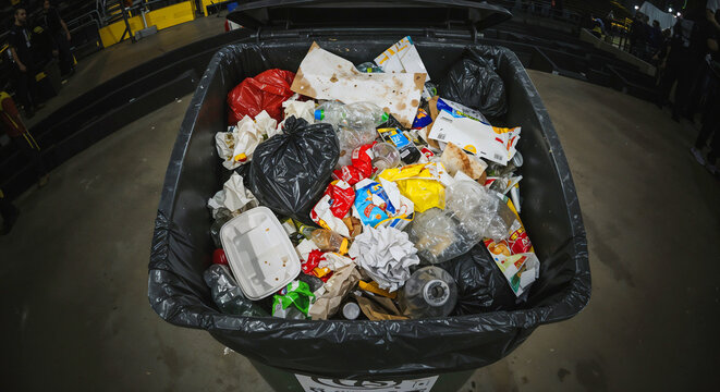 A large dumpster filled with a chaotic mix of discarded items, waste management