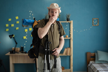 shocked traveler looking camera during mountain trip preparation