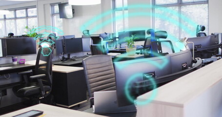 Displaying light wood desks with monitors and laptops in open-plan office, with network holograms