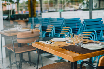 Empty restaurant table setup with stacked blue chairs