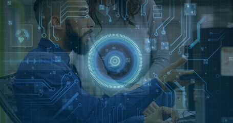 Collaborating developer and UX designer reviewing monitor in tech office with circuit overlay