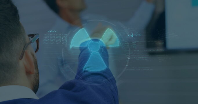 Pointing senior wearing suit manipulating floating radiation hazard symbol in boardroom, copy space - Powered by Adobe