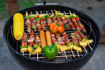 Variety of grilled skewers with vegetables and sausages on barbecue