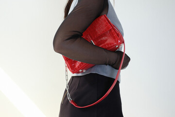 Business woman hold a beautiful red leather handbag on a white background