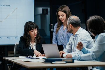 Young female colleague receives mentorship at a meeting in office