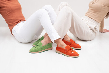 Two fashionable slim girls  sitting on the floor