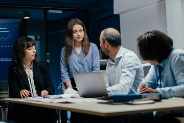 Young female colleague arriving late to business meeting in office