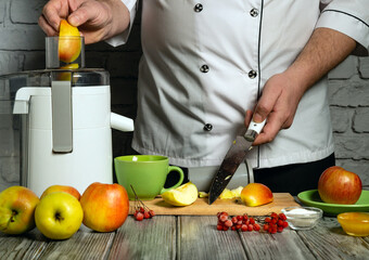A chef slices fresh apples and prepares to extract juice using a machine. Bright apples and berries...