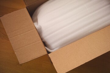 An open cardboard box with a packaged item inside