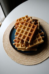 belgian waffles on a plate, round napkin and white table