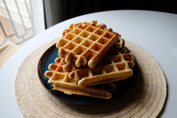 belgian waffles on a plate, round napkin and white table