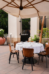 An Elegant Outdoor Dining Setup Featuring Stylish Umbrella and Comfortable Chairs