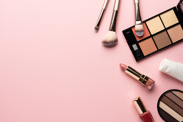 Makeup products flat lay background on pink.