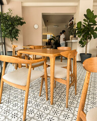 Bright and stylish cafe interior with wooden furniture and decorative plants in cozy setting