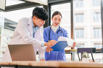 Medical professional and nurse discussing patient chart in modern hospital office, teamwork and collaboration in healthcare setting, bright natural light, focused and positive atmosphere