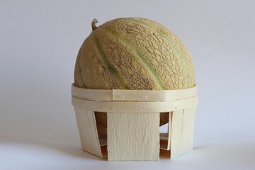 Whole Galia Melon in Wooden Basket on White Background