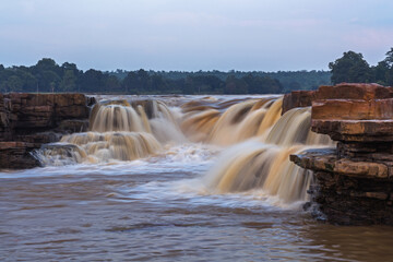 The flowing water over the rocks is captured by long exposure in this beautiful landscape during...
