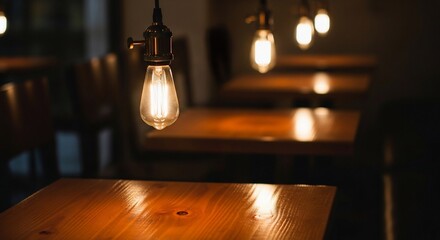 Warm Glow: Edison Bulbs Illuminate Wooden Tables in Dim Restaurant Ambiance