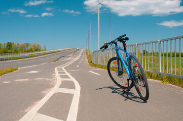 Bicycle at bike path in country near roadway in summer