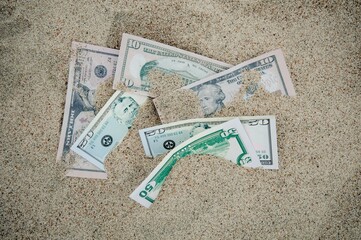 Hidden dollar banknotes at a sandy beach